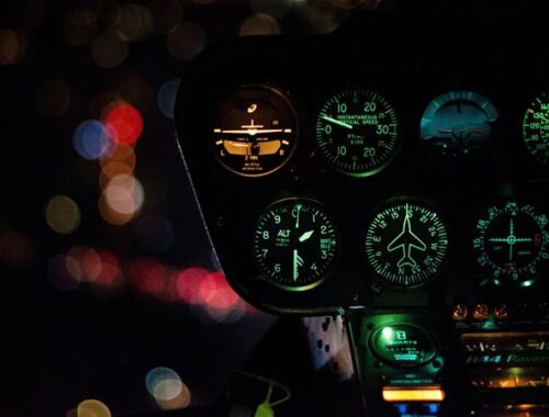 Illuminated dashboard dials of a helicopter flying at night