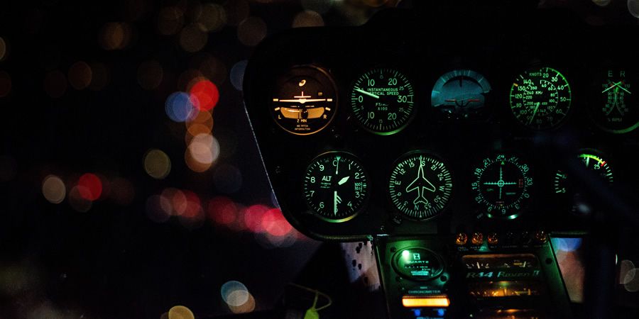 Illuminated dashboard dials of a helicopter flying at night