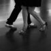 Close-up of dancers’ feet stepping across a polished floor