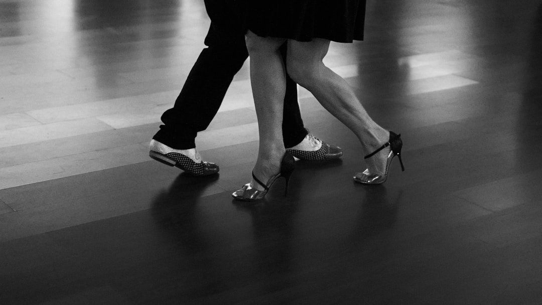 Close-up of dancers’ feet stepping across a polished floor
