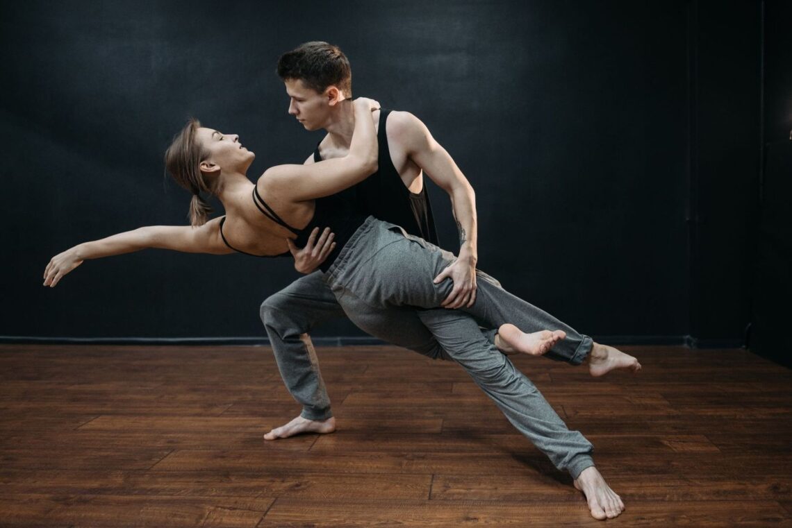 Two dancers demonstrate a supported, extended partner-dance position