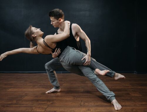 Two dancers demonstrate a supported, extended partner-dance position