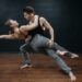 Two dancers demonstrate a supported, extended partner-dance position
