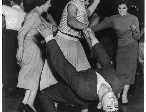 Black-and-white photo of energetic couples dancing on a social floor