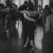 Dancers navigating a crowded ballroom floor in close partner holds