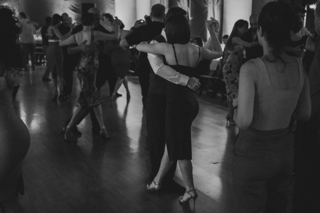 Dancers navigating a crowded ballroom floor in close partner holds